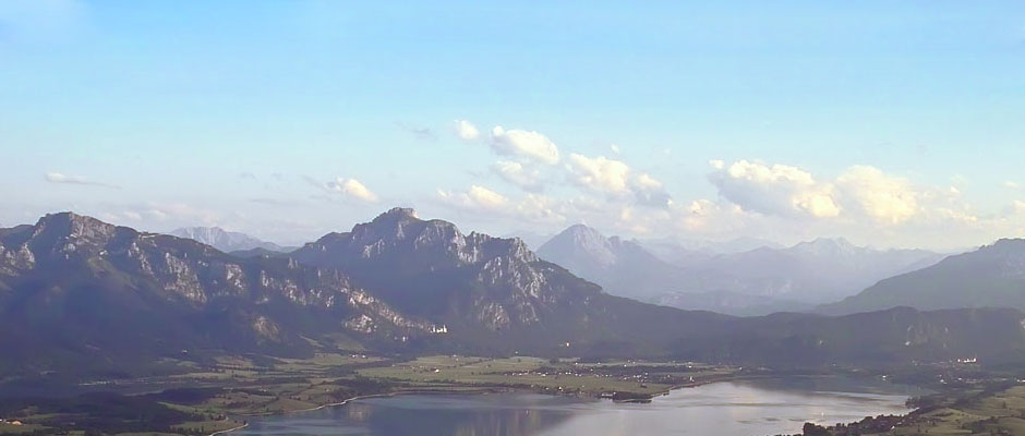 Der Forggensee vor den Allgäuer Alpen und dem Schloss Neuschwanstein